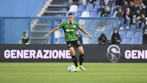 Aksi Jay Idzes menggiring bola dengan jersey strip hijau-hitam Sassuolo saat melawan Fiorentina.